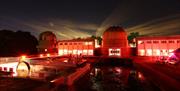 Picture of telescopes at observatory science centre in dark lit lighting with red mood lighting