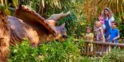 Image of a family looking at a dinosaur at the Jurassic jungle at Drusillas Park