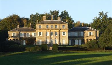 an impressive house with 3 buildings over 3 floors stood behind green gardens