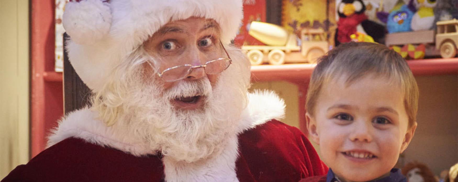 Santa with a Child at a Christmas Grotto