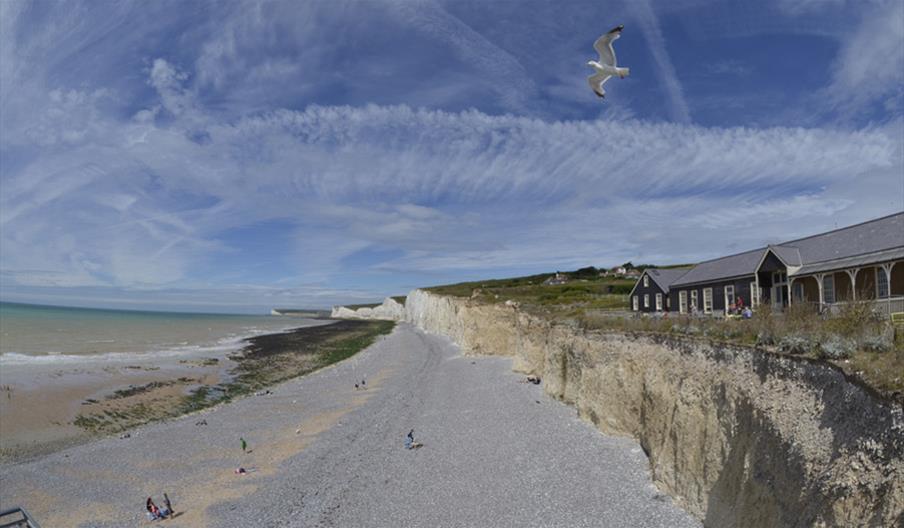 a pebble beach with white cliffs and blue skies