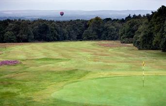 Crowborough Golf greens with hot air balloon flying over