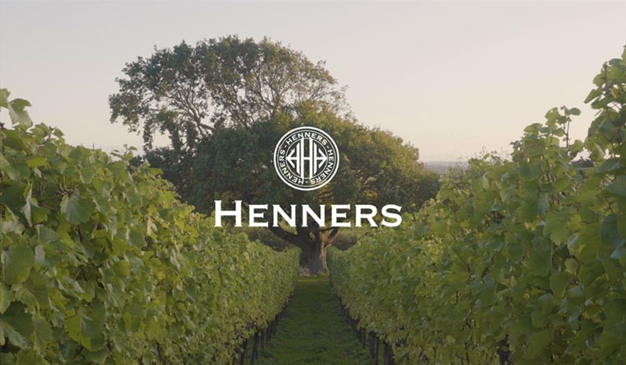a pathway with vines either side with a white logo in the middle saying henners