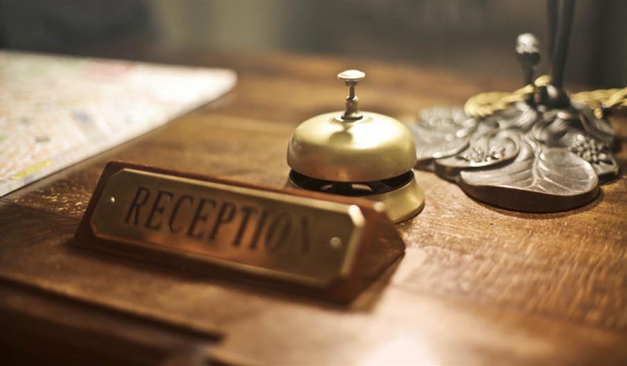 reception desk with sign and bell