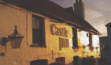 The outside of the Castle Inn pub at dusk.