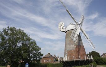 brick windmill with white sails