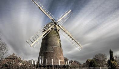 brick windmill with white sails