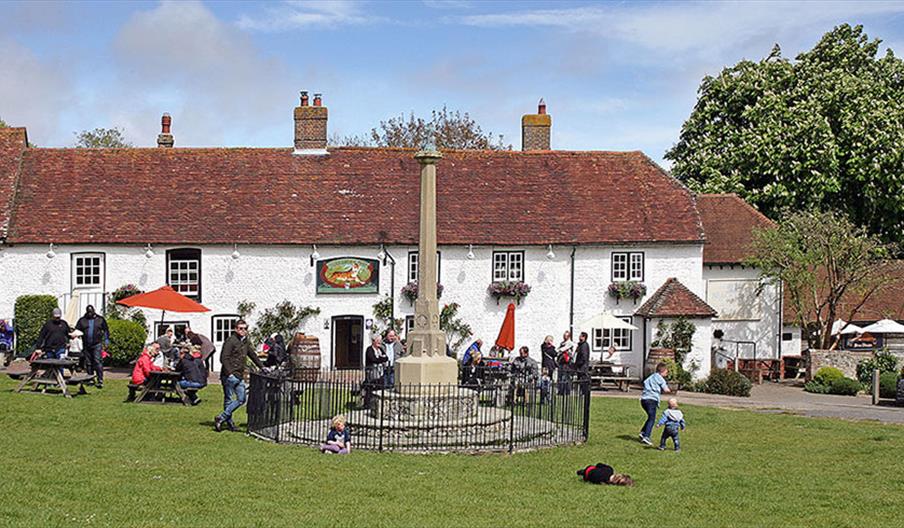 Exterior shot of Tiger inn with people sitting outside