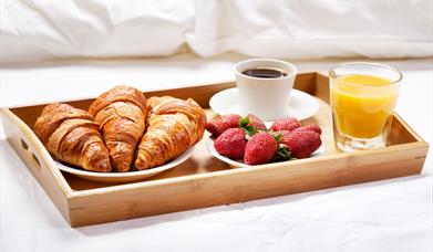 Breakfast tray of croissants and strawberries and drinks