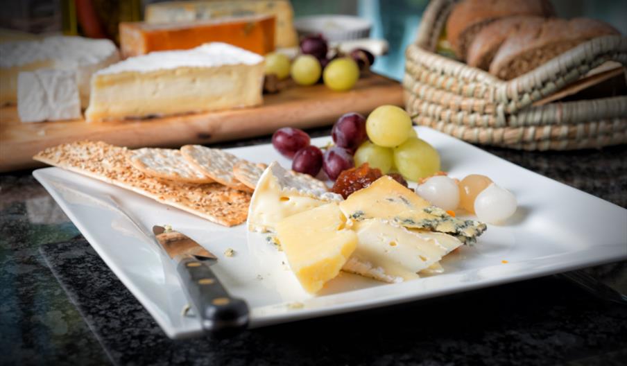 Cheese plate with crackers and grapes and onions