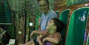 image of a son and his mum on the dino drop ride