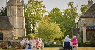 People sat outside in sunshine in countryside