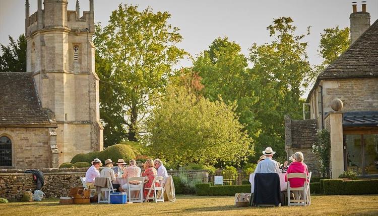 People sat outside in sunshine in countryside