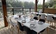 Cafe with tables and chairs with a view over the lake.