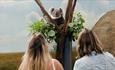 two women looking up at a koala in a tree