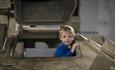 Boy exploring tank at REME Museum