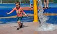 Oliver, aged 8, running through water fountain