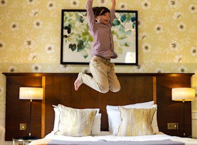 Child jumping on bed at Royal Berkshire Hotel