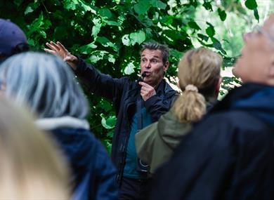 Julian talking to a group amongst the trees