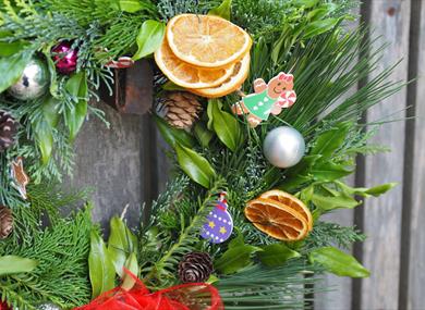 Christmas wreath with fir cones, baubles, gingerbread person and dried orange