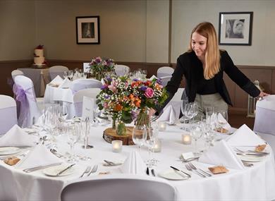 Wedding coordinator putting flowers on a table