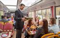 Person pouring a glass of prosecco for a passenger on Golden Tours Royal Windsor Afternoon Tea Bus Tour