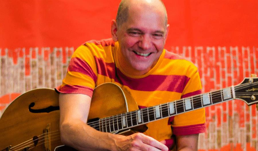 Andy Fite - Jazz Comic Philosopher - Laughing while holding guitar