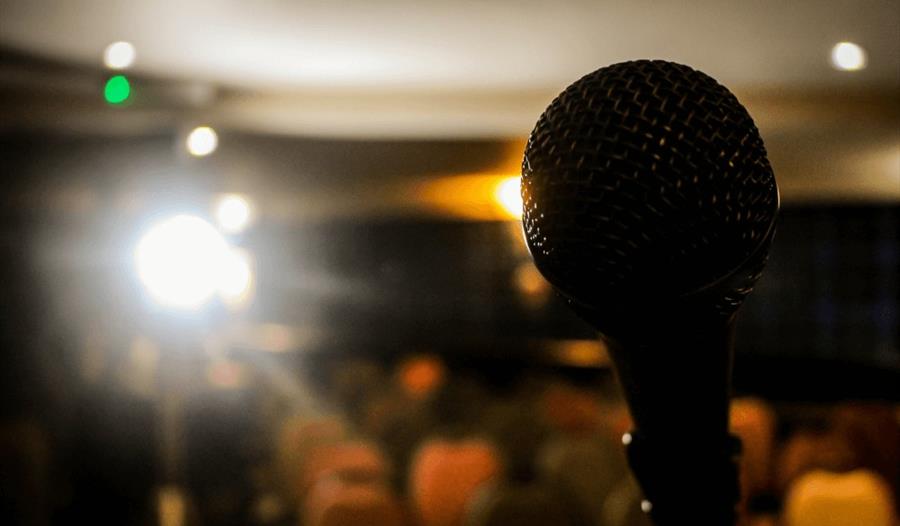 Open Mic - a microphone illuminated by a spotlight