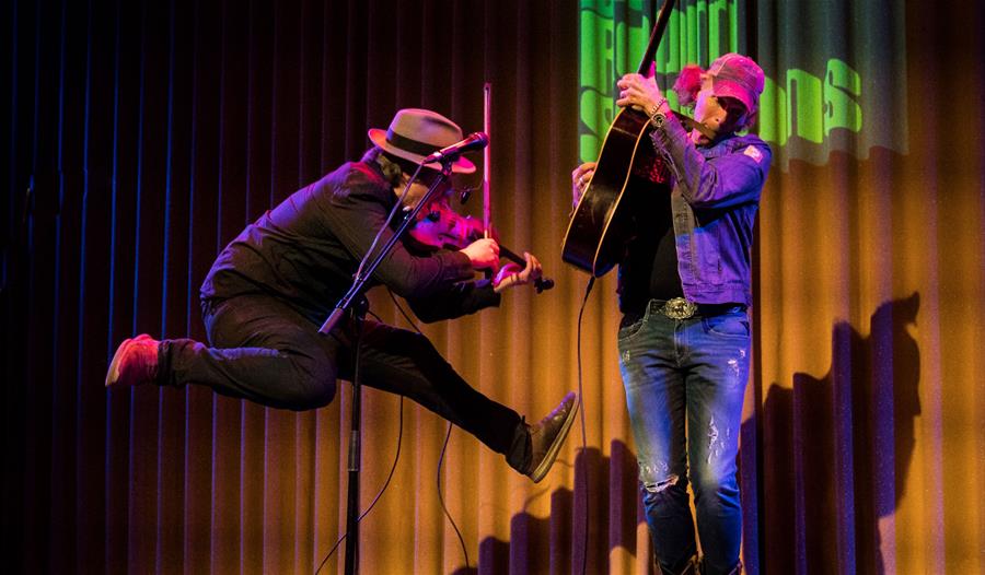 Brooks Williams and Aaron Catlow - performing on stage, jumping