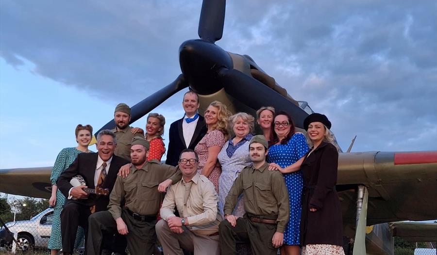 A Feast of the 40s - Maidenhead Musical Comedy Society - group in front of a spitfire