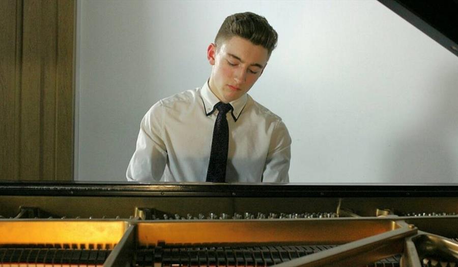 Henry Cash - sat at a piano