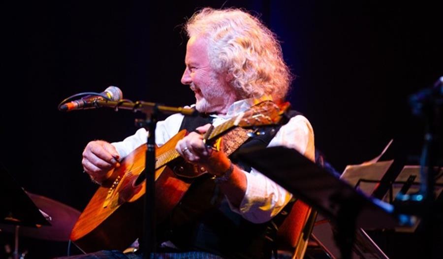 Reg Meuross - playing guitar