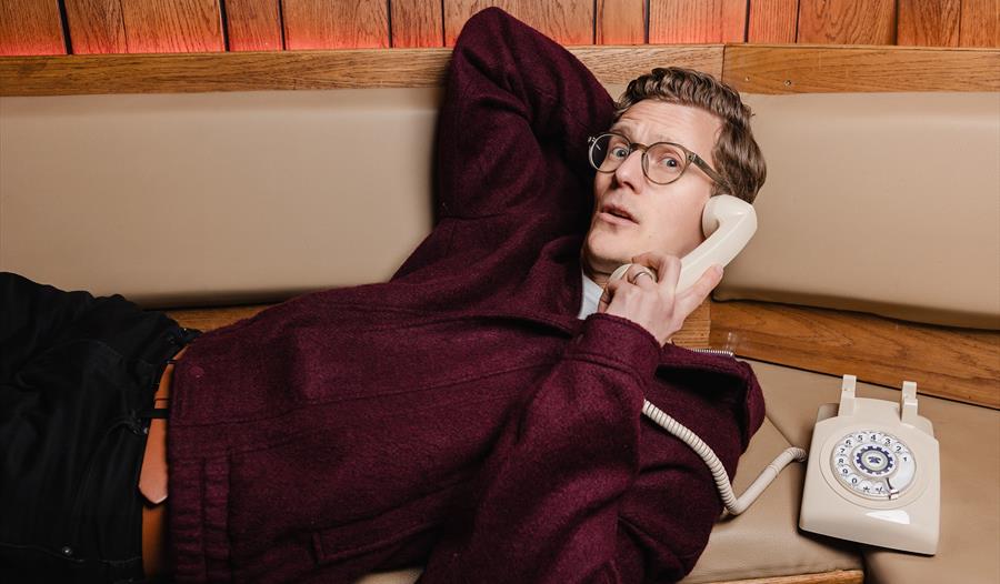 Robin Morgan - laid back, talking on a rotary telephone