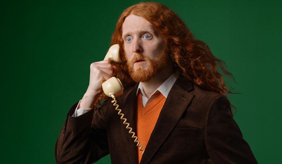 Alasdair Beckett-King holding a phone