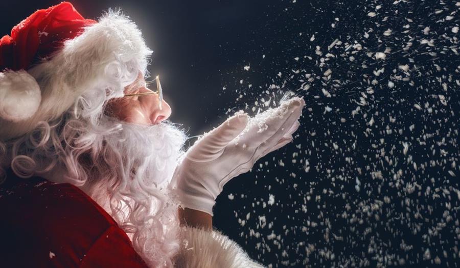 Father Christmas blowing snowflakes from his hand