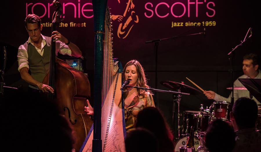 Tara Minton - performing on stage at Ronnie Scott's with harp