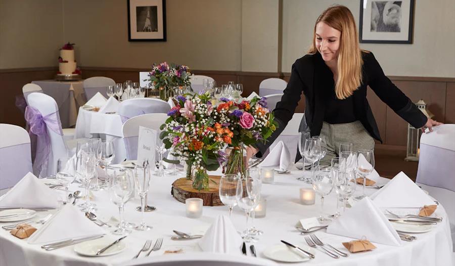 Wedding coordinator putting flowers on a table