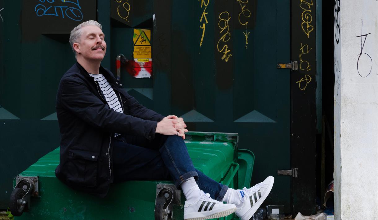 Carl Donnelly - sat posed on a tipped over bin
