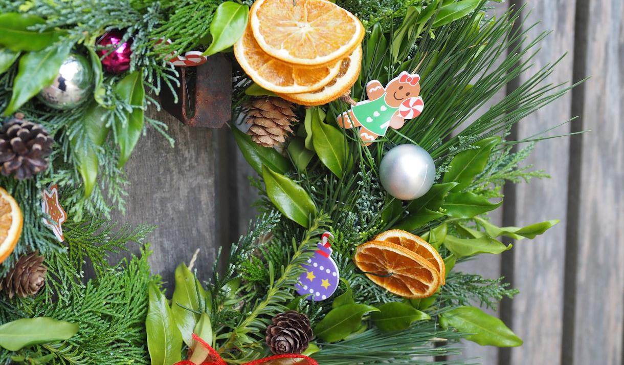 Christmas wreath with fir cones, baubles, gingerbread person and dried orange