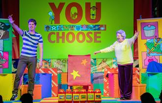 You Choose - performers on stage with bright props and background