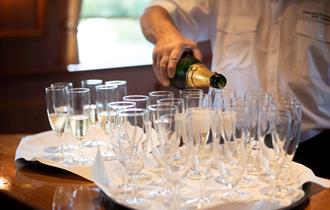 Windsor & Maidenhead Boat Company crew pouring Champagne