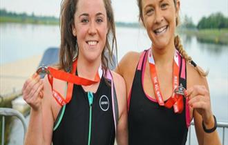 Two triathletes with their medals