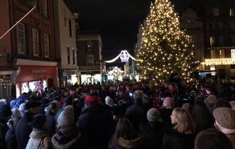 Carols on the Hill - crowd singing around the Christmas tree and with military band, Christmas lights in background