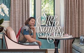 Step into another realm | person in battle dress sitting in Fairmont Windsor Park lounge, helmet on chair and horse visible through the window