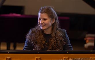 Khrystyna Mykhailchenko - young woman sat at a piano