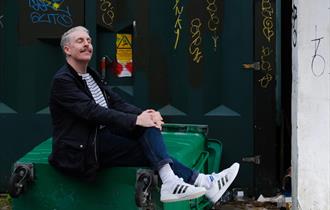 Carl Donnelly - sat posed on a tipped over bin
