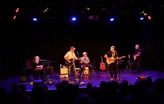 JJ Cale Story - band playing on stage