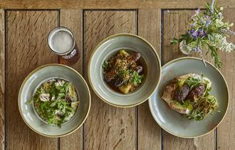 Three dishes of food and a pint of beer
