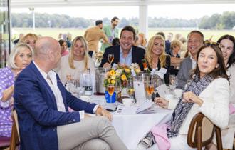 People gathered around a table enjoying hospitality at Guards Club Polo