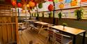 A spacious wooden deck equipped with tables and chairs for al fresco dining.